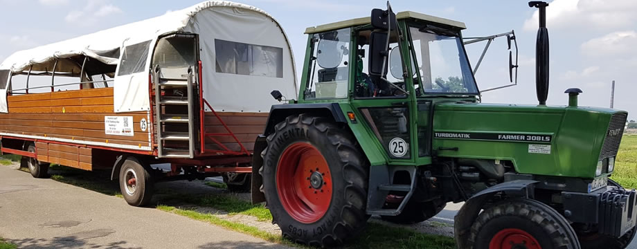 Planwagen mit Traktor auf einem Feldweg am Niederrhein